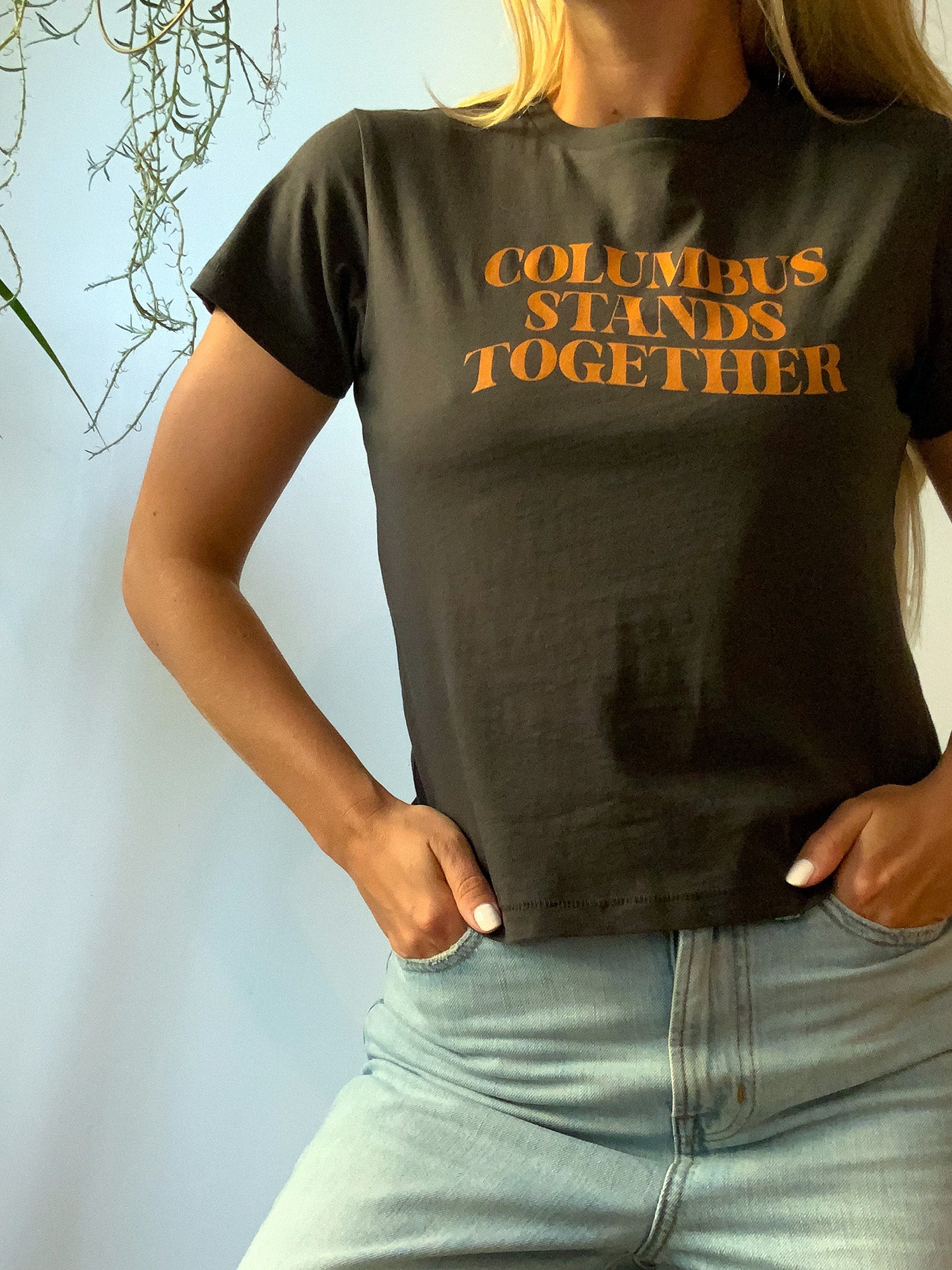 Cropped vintage black high-waisted tee with Columbus Stands Together tan graphic at front.