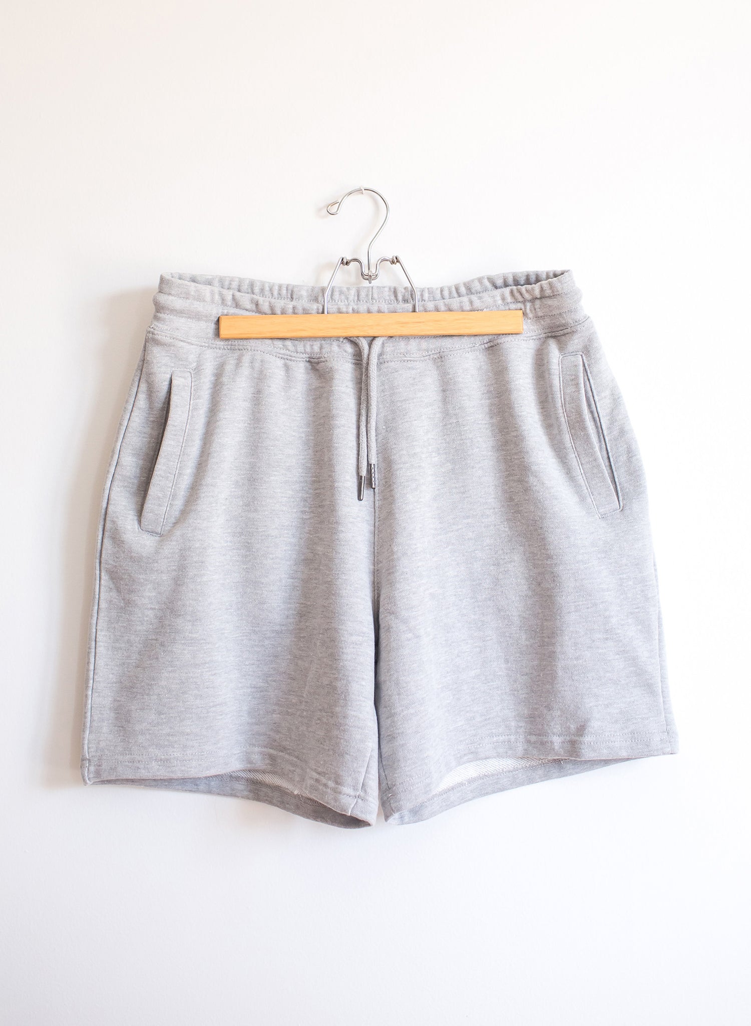 Hanging pair of heather grey cotton sweatshorts with drawstring and pockets at side