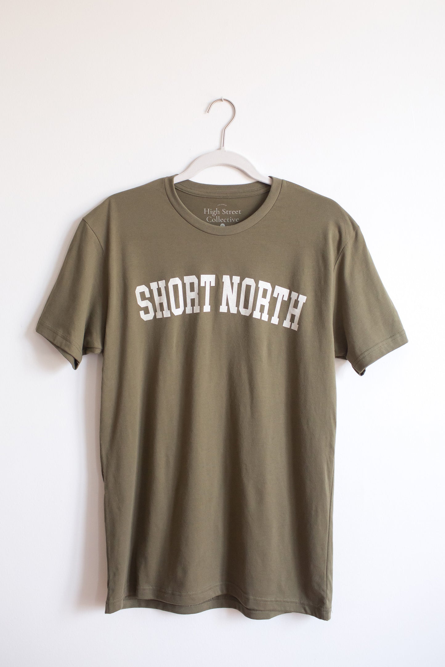 Dusty green sueded crewneck tee with white Short North graphic at front.