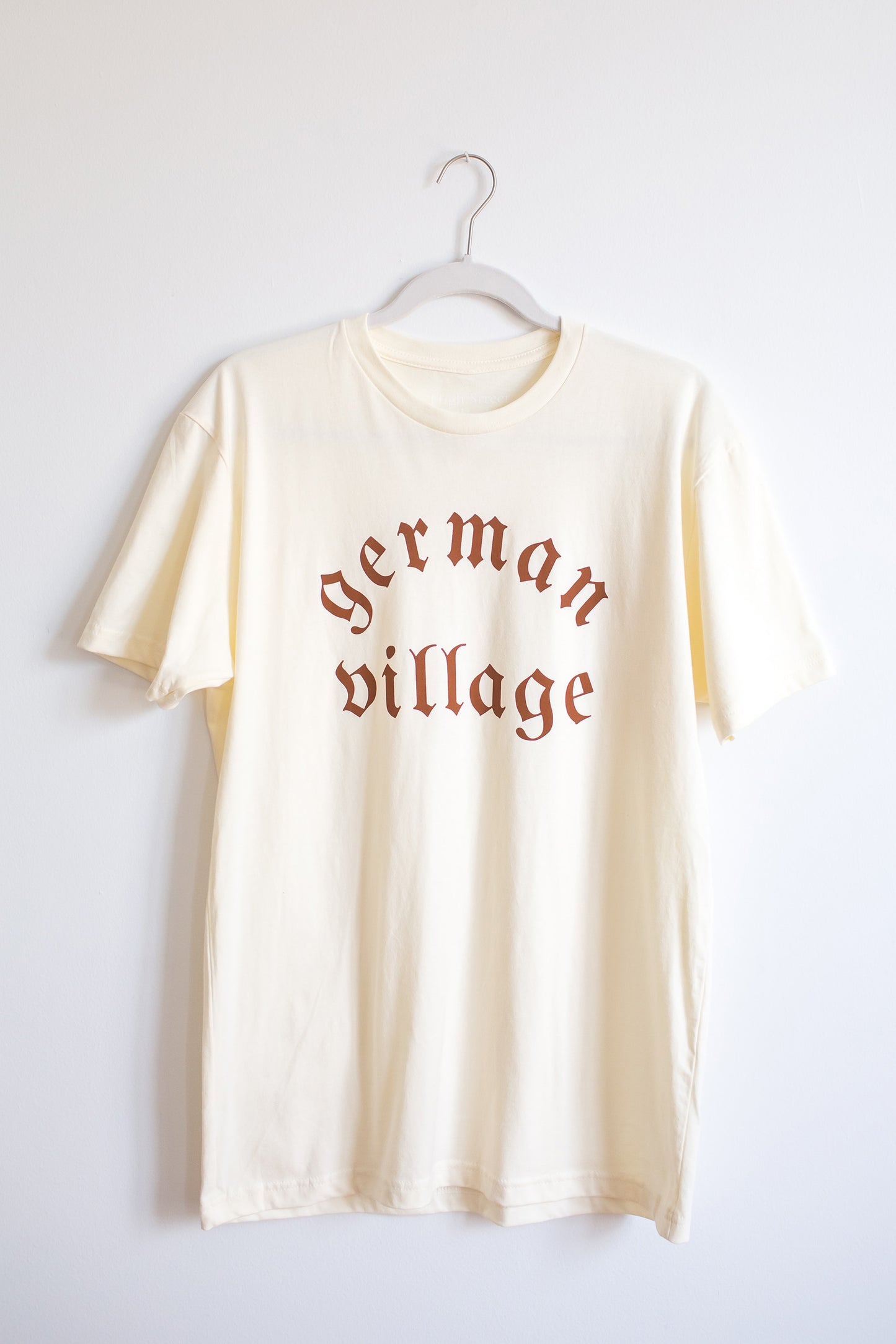 Hanging cream colored cotton crewneck tee with German Village graphic at front