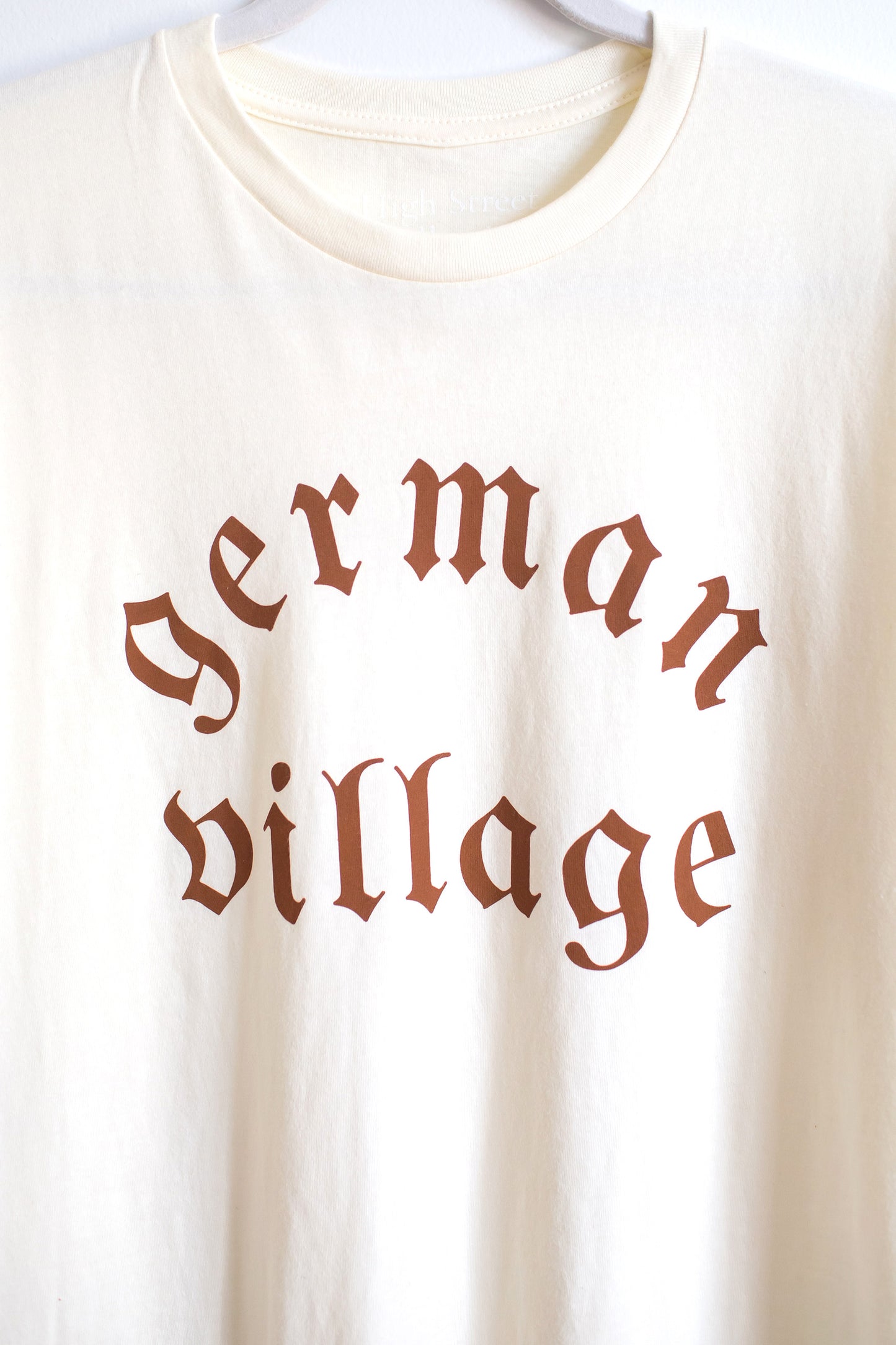 Zoomed in shot of German Village graphic on front of cream colored cotton crewneck tee