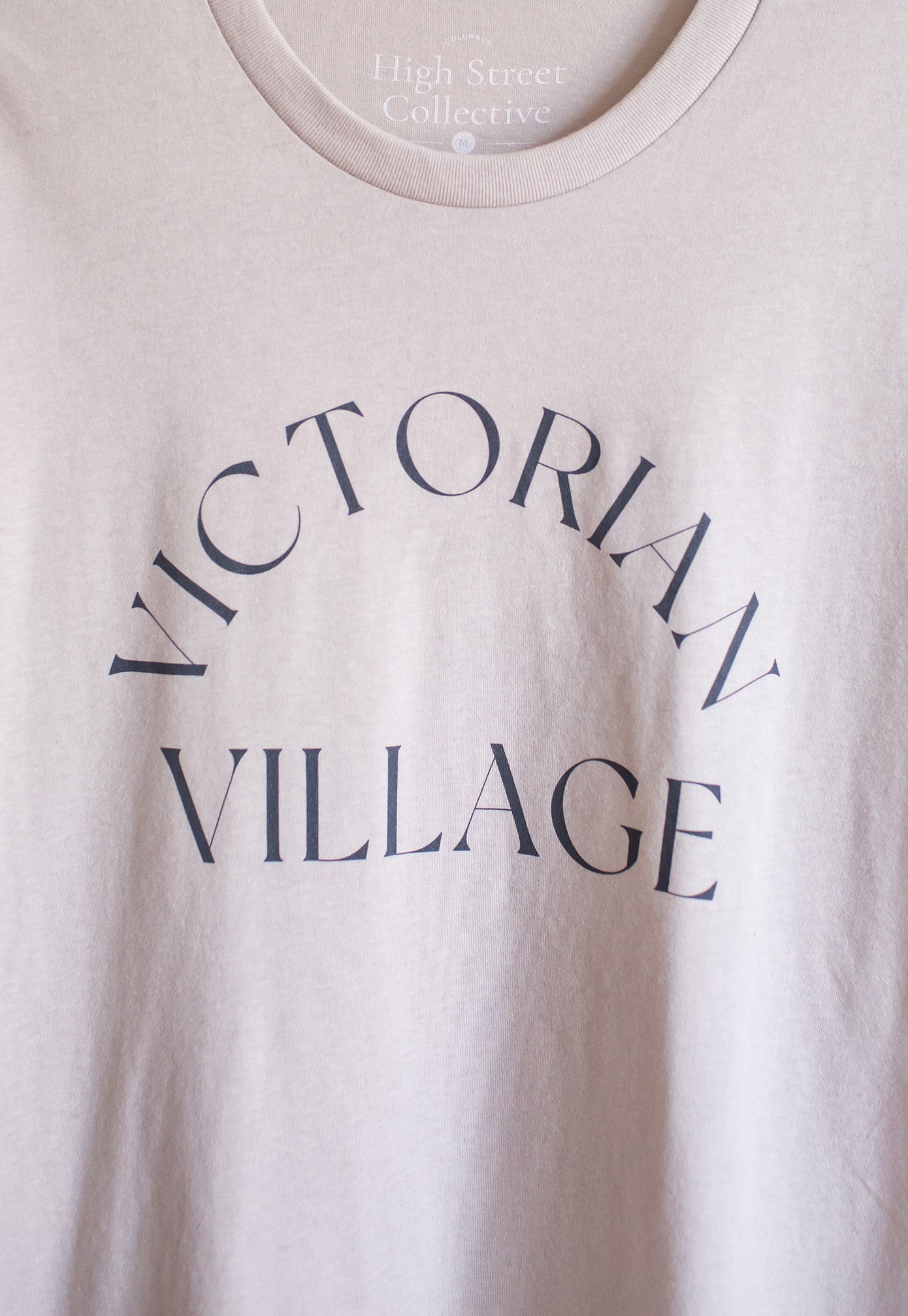 Close up of Victorian Village graphic on light grey sueded tshirt.