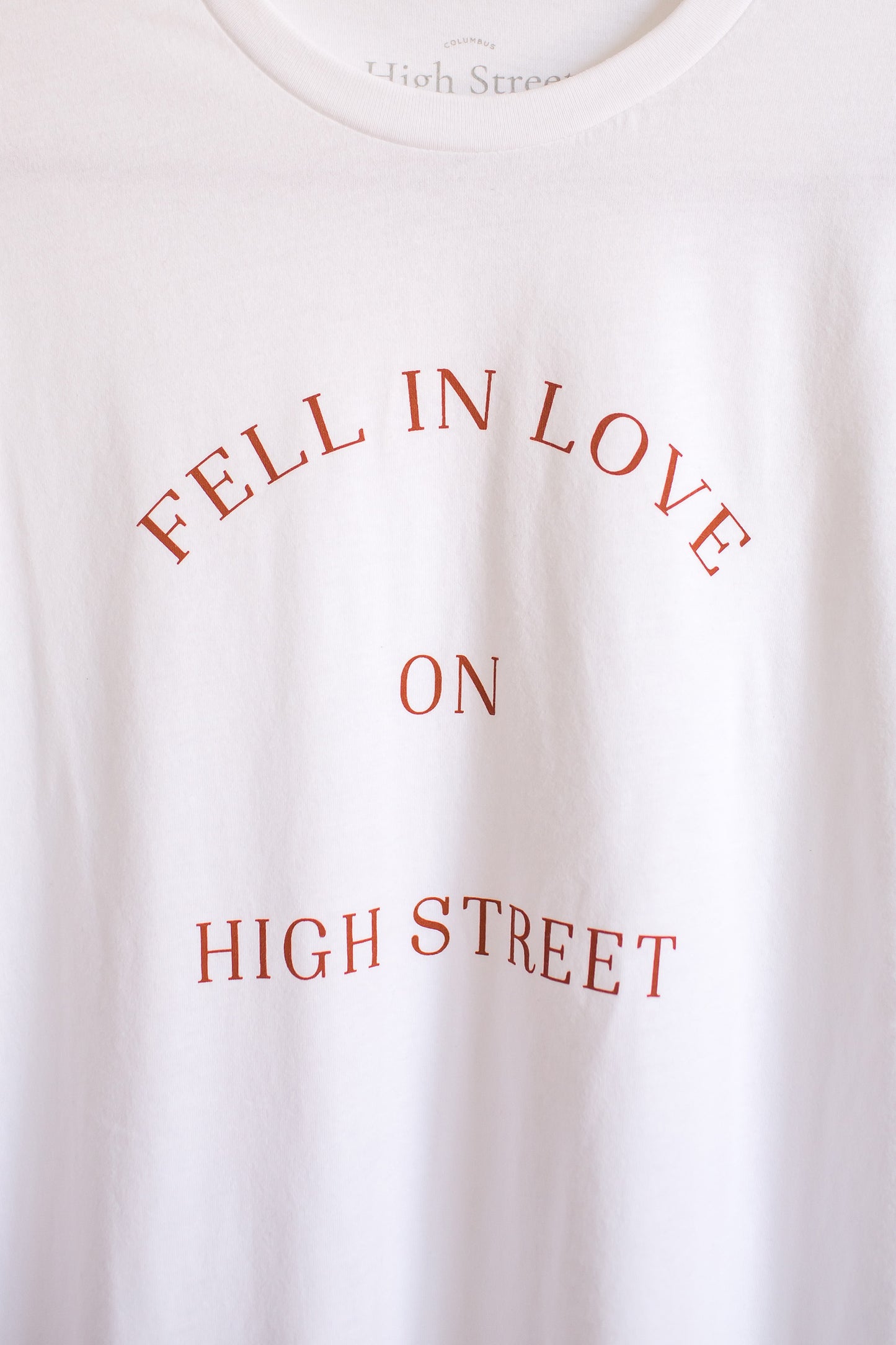 Zoomed in shot of Fell In Love On High Street graphic on white sueded crewneck tee