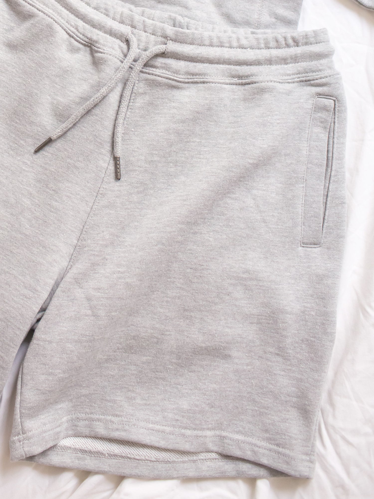 Zoomed in shot of heather grey cotton sweatshorts with drawstring waistband and pockets
