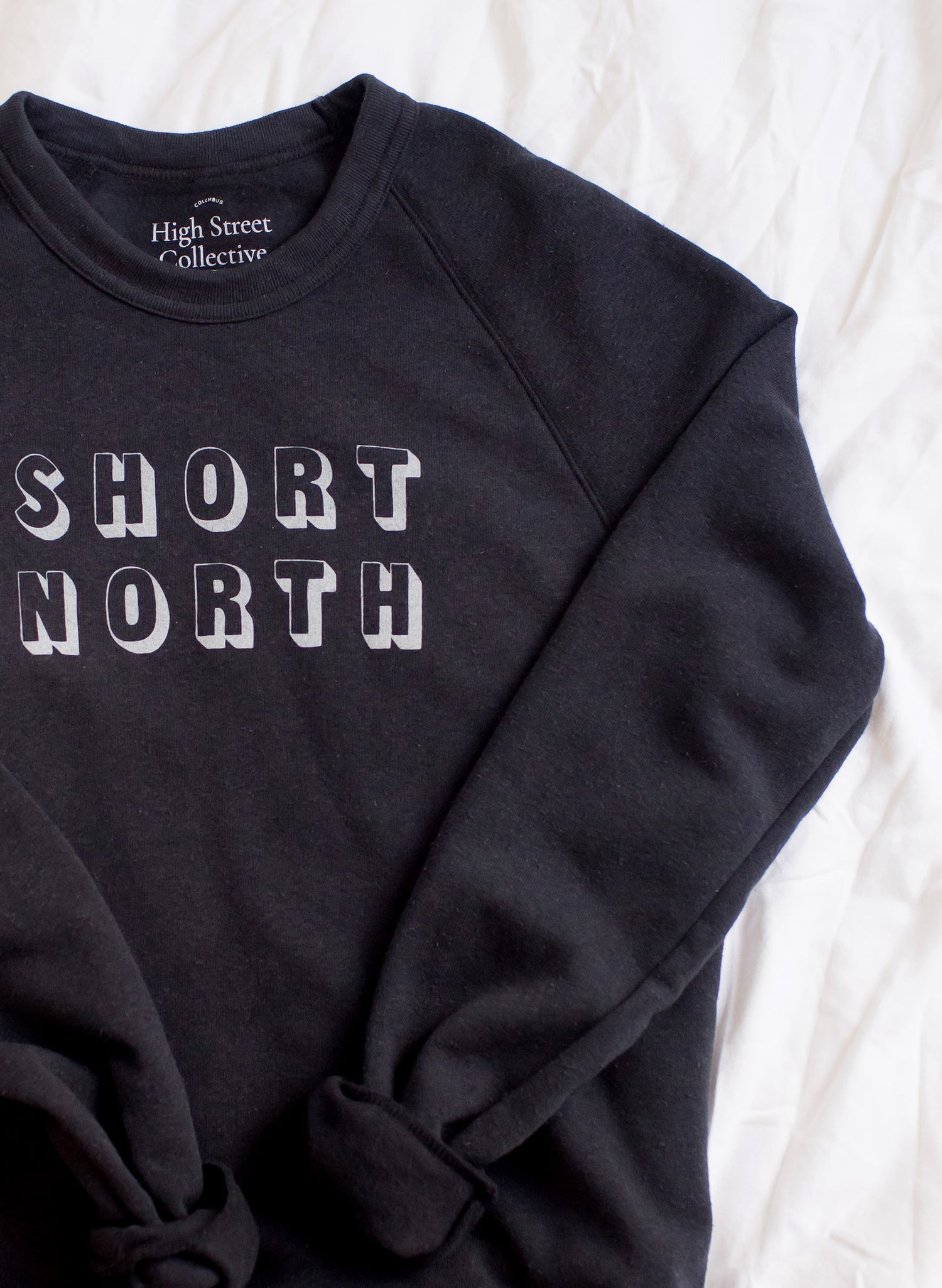 Black crewneck sweatshirt with Short North graphic in white.
