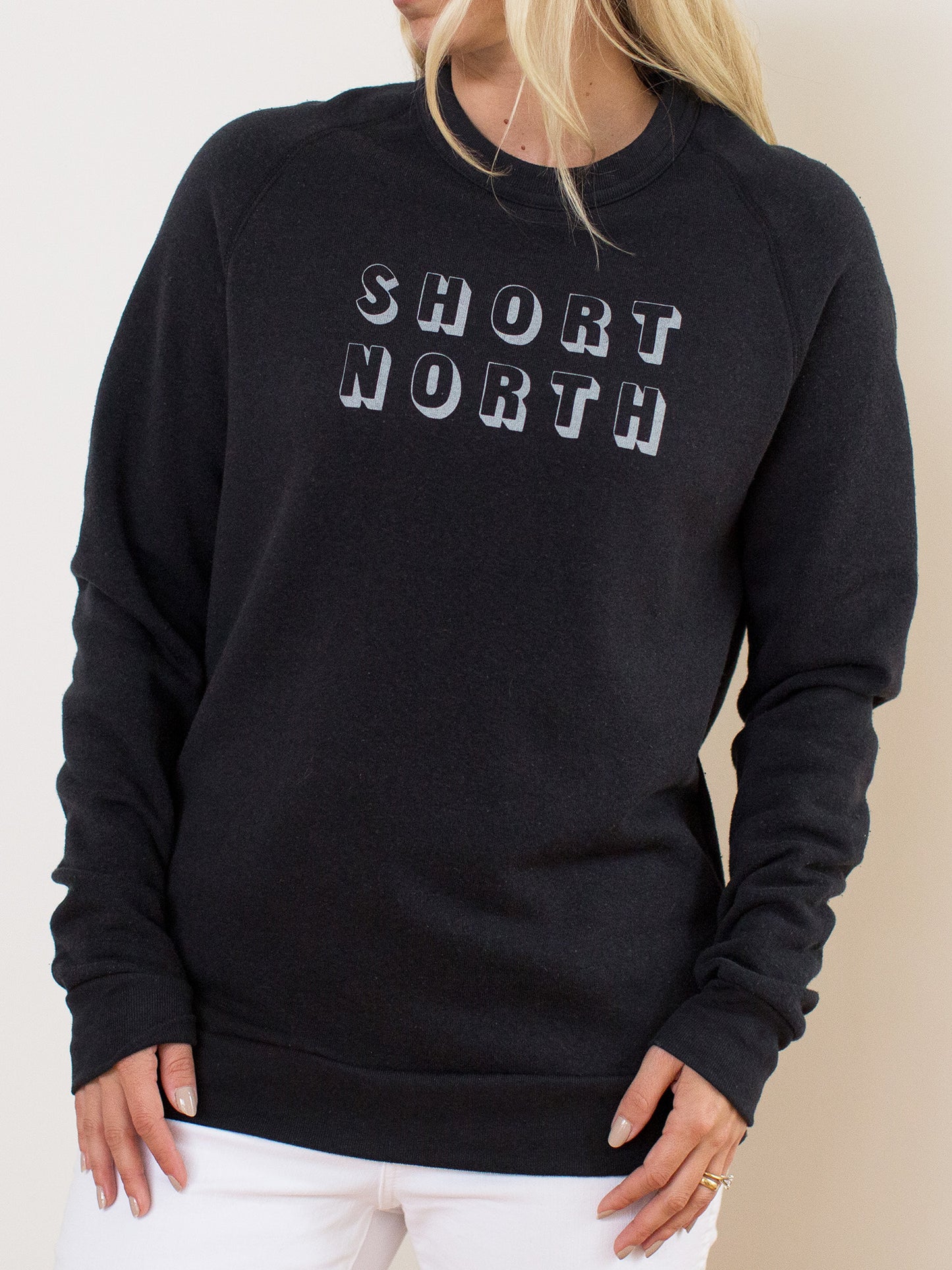 Model wearing black crewneck sweatshirt with Short North Columbus, Ohio graphic at front
