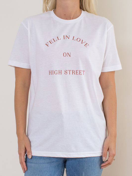 Model wearing white sueded tee with Fell In Love On High Street graphic at front