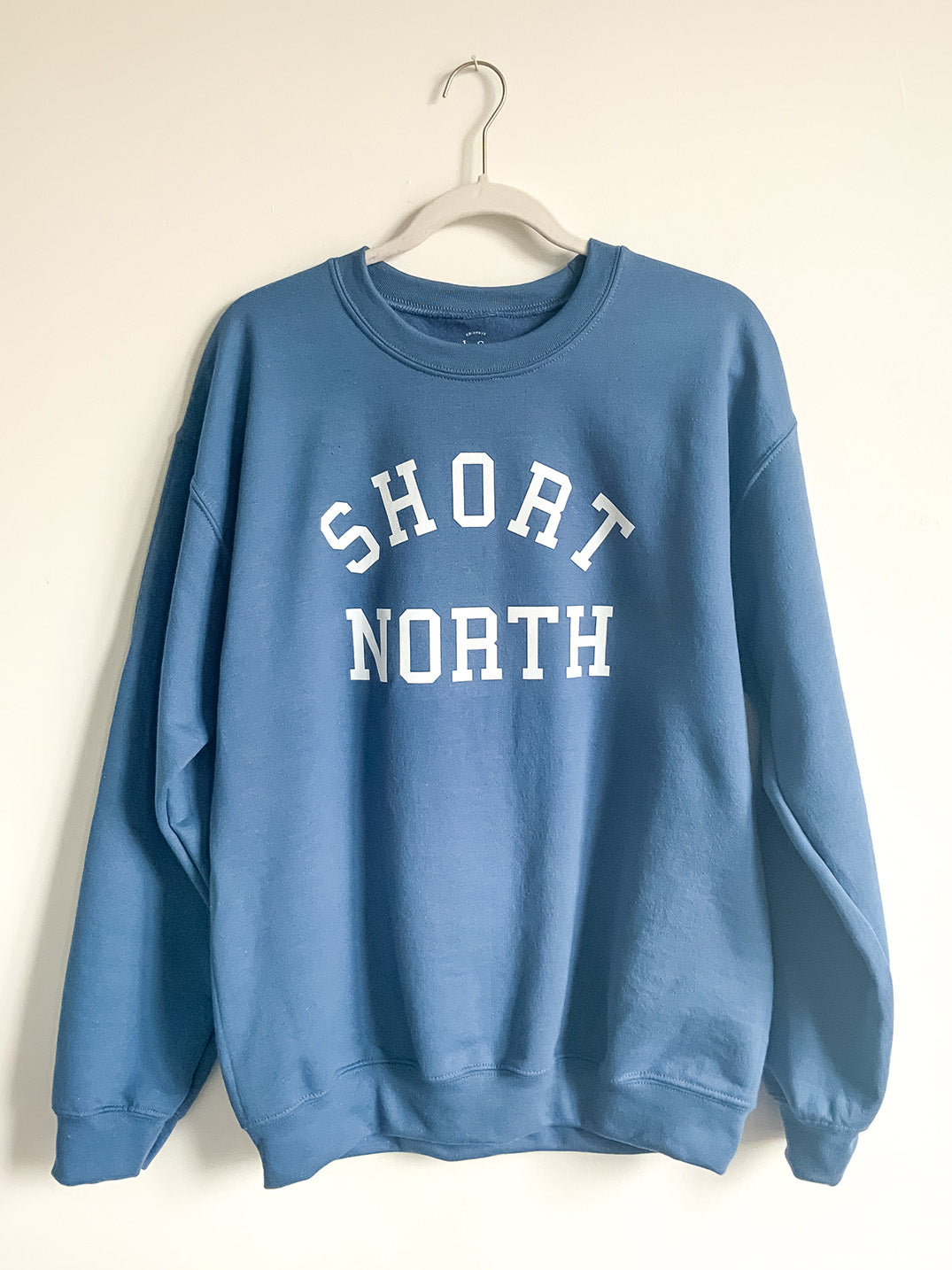 Hanging indigo blue Short North crewneck sweatshirt.