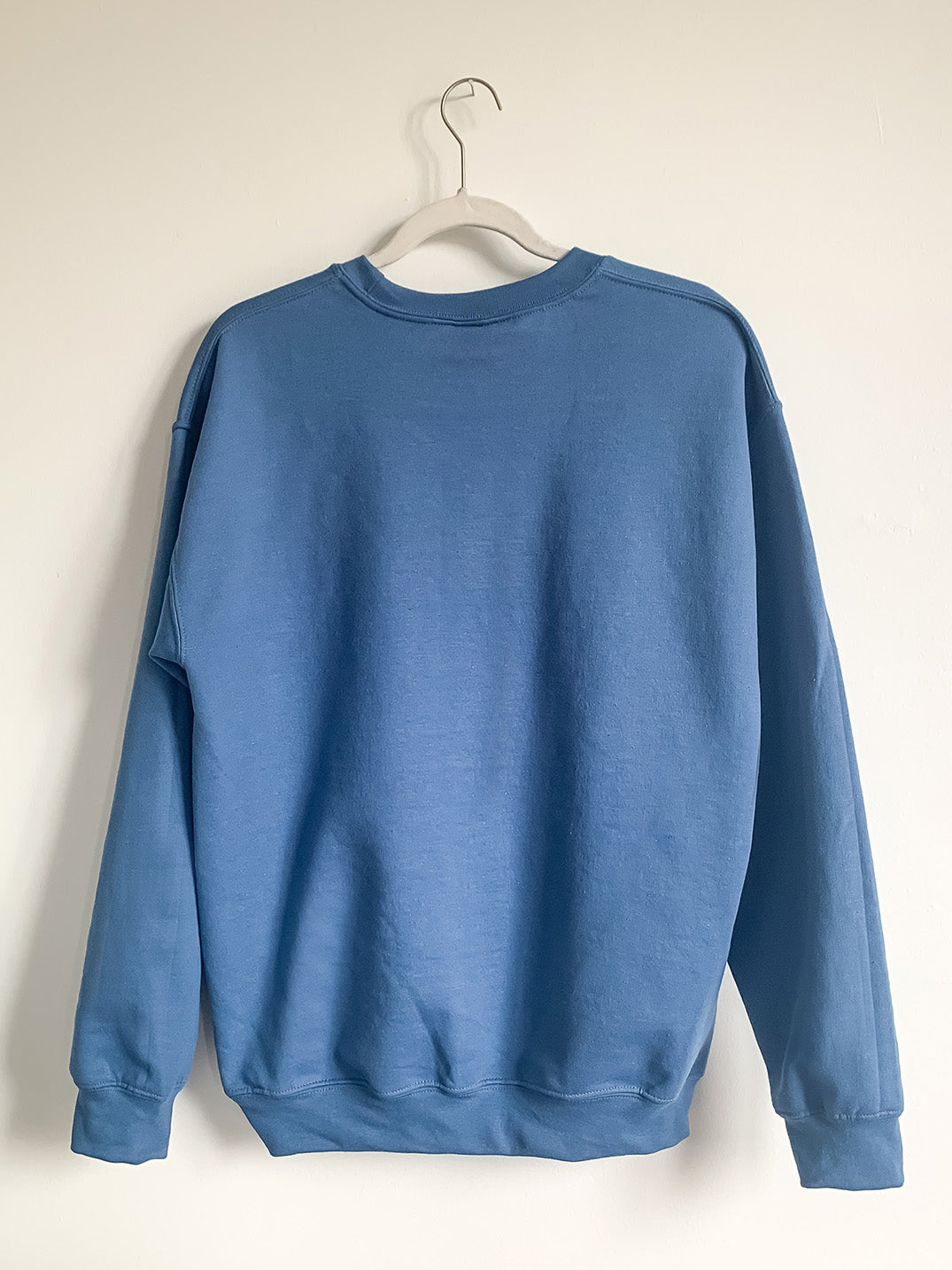Back of hanging indigo blue Short North crewneck sweatshirt.